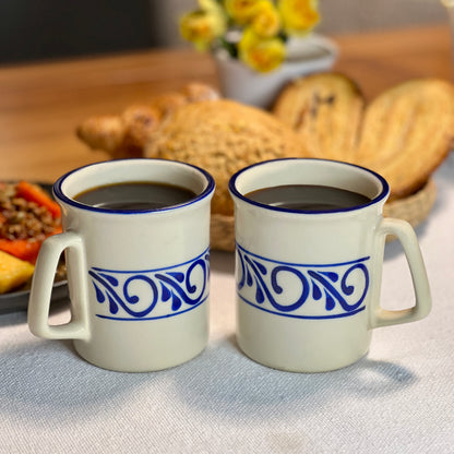 Set of two ceramic mugs with hand-painted designs, ideal for enjoying morning coffee or tea.
