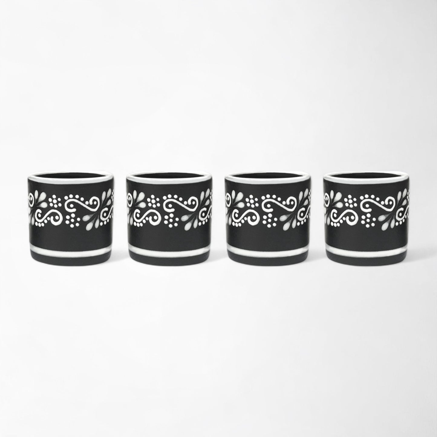 Handcrafted Mexican ceramic mezcal cup set with four black and white glasses shot glasses