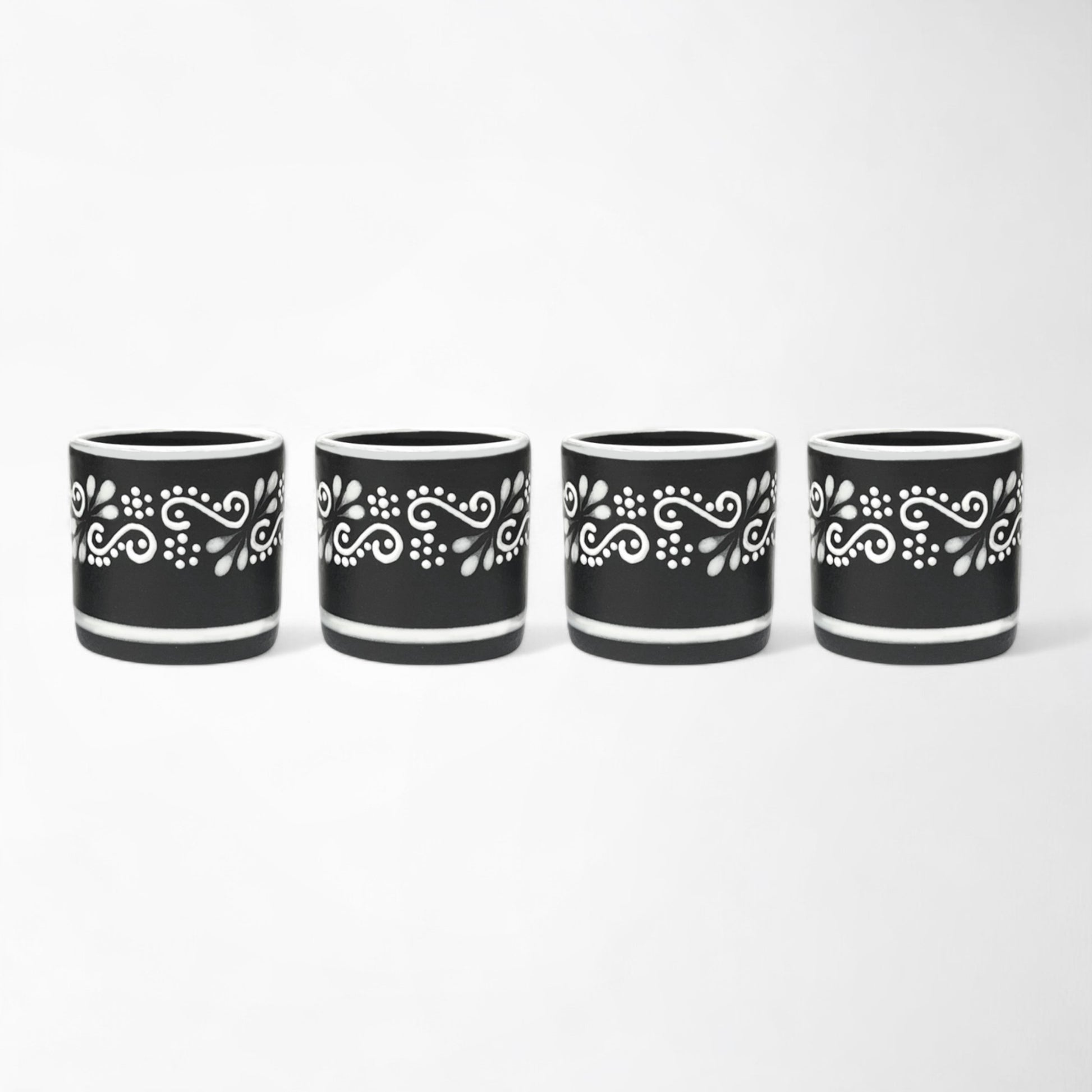 Handcrafted Mexican ceramic mezcal cup set with four black and white glasses shot glasses