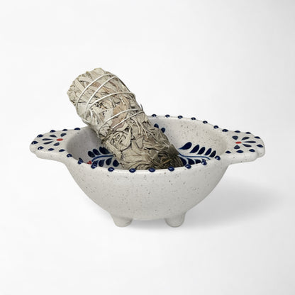 Ceramic bowl with red and blue decorative pattern used for spiritual cleansing and smudging rituals.