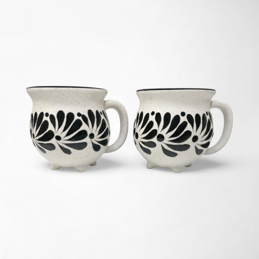 Pair of mugs with black and white patterns, adding decor to a kitchen or dining area.