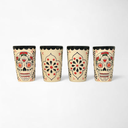 Four decorative ceramic shot glasses with detailed hand painted Day of the Dead sugar skulls